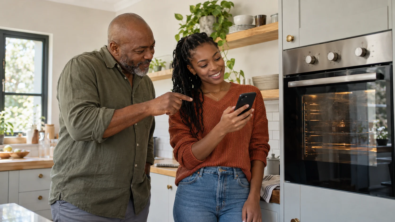 Father and adult daughter checking an appliance completion alert on a phone.